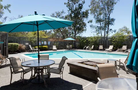 a view of patio with chairs and table under an umbrella