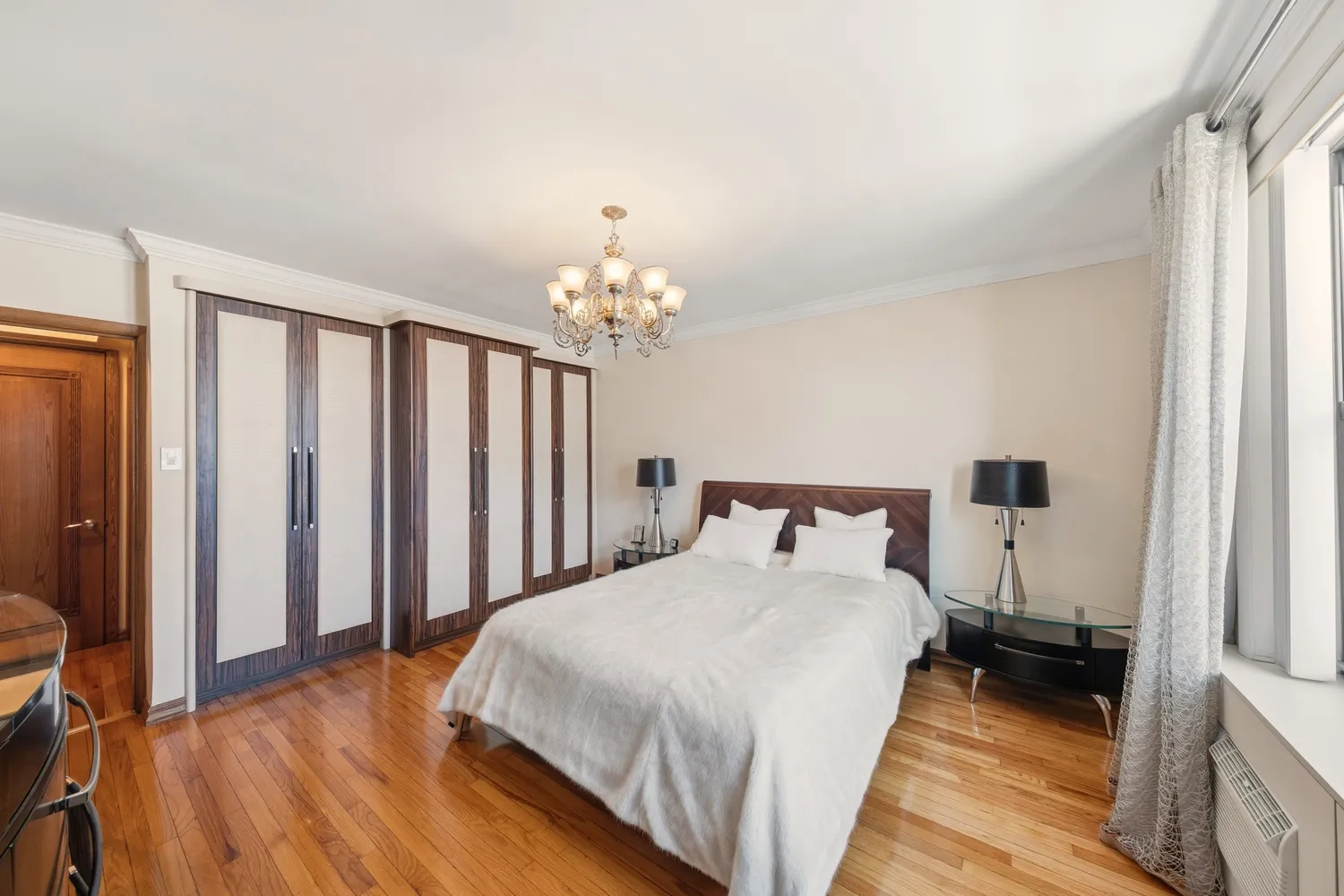 a bedroom with bed and a chandelier