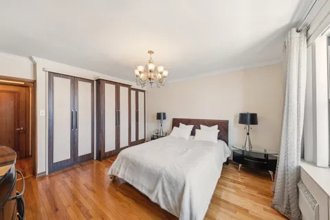 a bedroom with bed and a chandelier