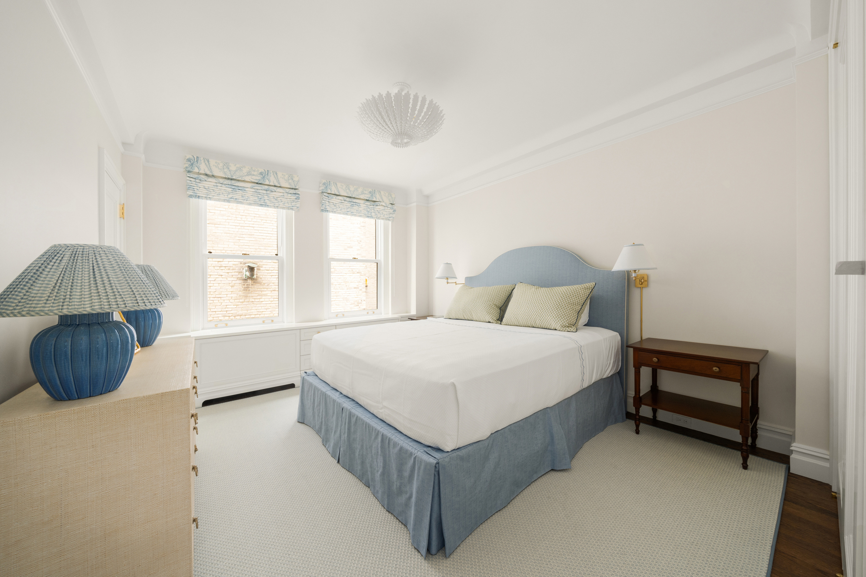 108 East 82nd Street, Unit 7C Manhattan, NY 10028 - Photo 4 of 9 a bedroom with a bed a window and a chandelier
