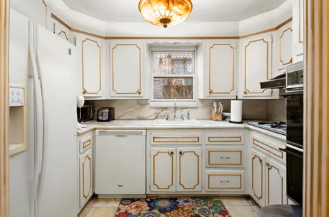 a kitchen with cabinets appliances a sink and a counter top space