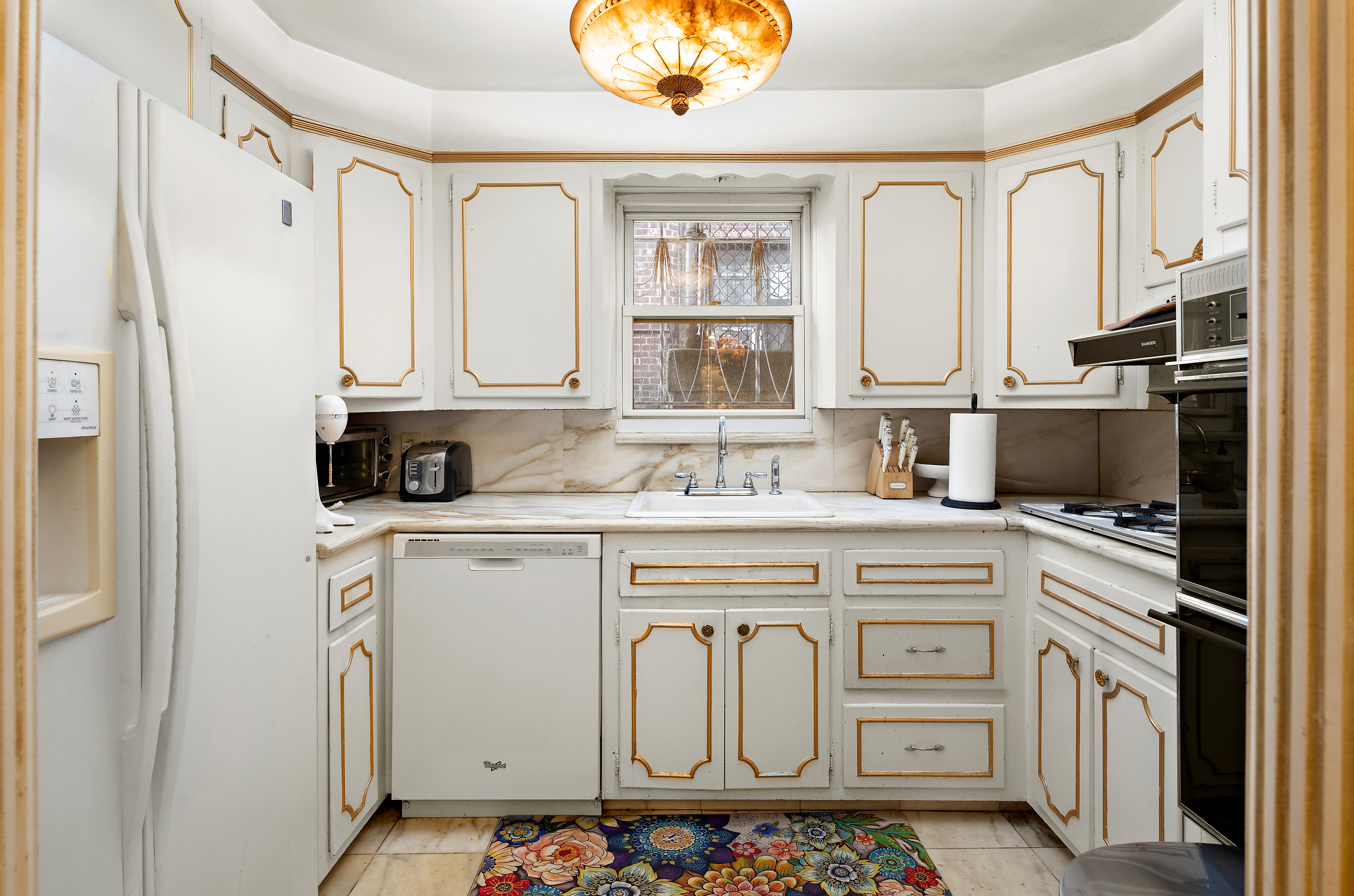 562 84th Street Brooklyn, NY 11209 - Photo 9 of 25 a kitchen with cabinets appliances a sink and a counter top space