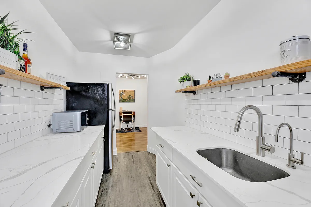 9040 Fort Hamilton Parkway, Unit 4G Brooklyn, NY 11209 - Photo 6 of 12 a kitchen with stainless steel appliances a sink a stove top oven a counter space and cabinets