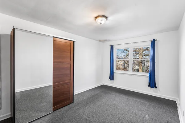 an empty room with windows and closet