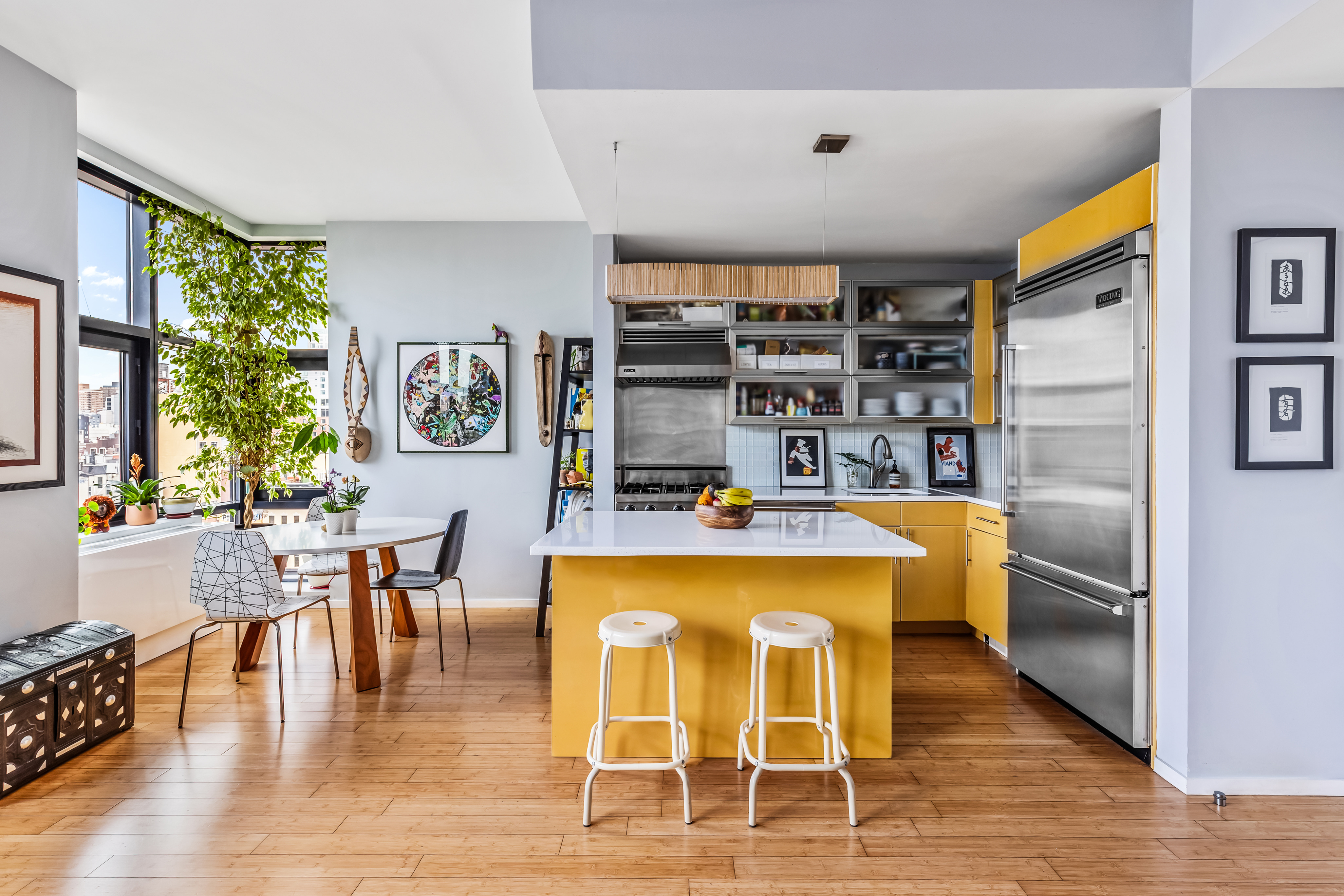 105 Norfolk Street, Unit 10A Manhattan, NY 10002 - Photo 3 of 11 a kitchen with stainless steel appliances granite countertop a stove top oven a sink a dining table and chairs with wooden floor
