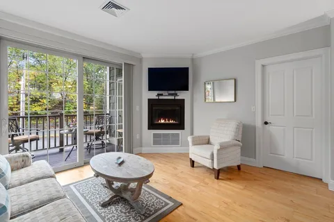 a living room with furniture a flat screen tv and a floor to ceiling window