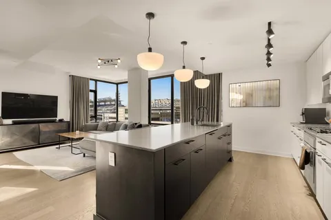 a large kitchen with kitchen island a sink and a large window