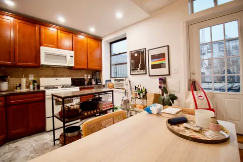 a living room with furniture kitchen and a large window