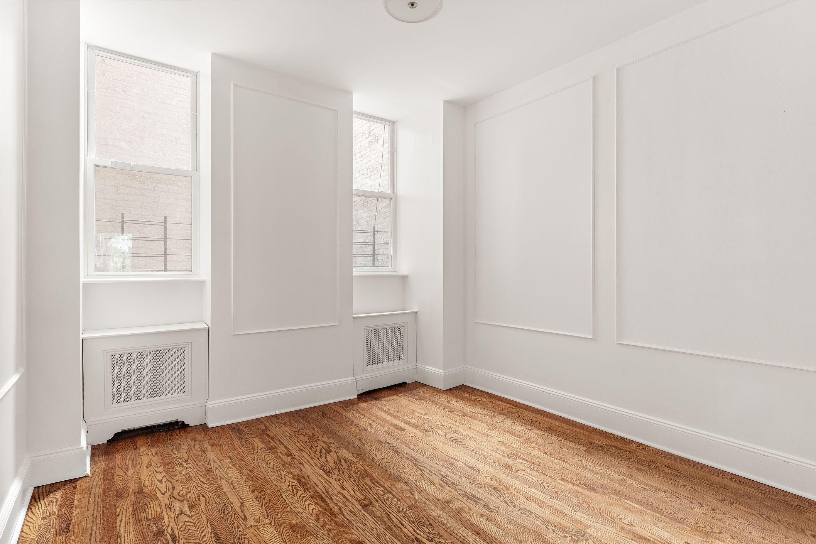 129 East 61st Street, Unit 3 Manhattan, NY 10065 - Photo 11 of 13 an empty room with wooden floor and windows