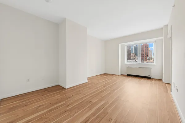 a view of a room with wooden floor and window