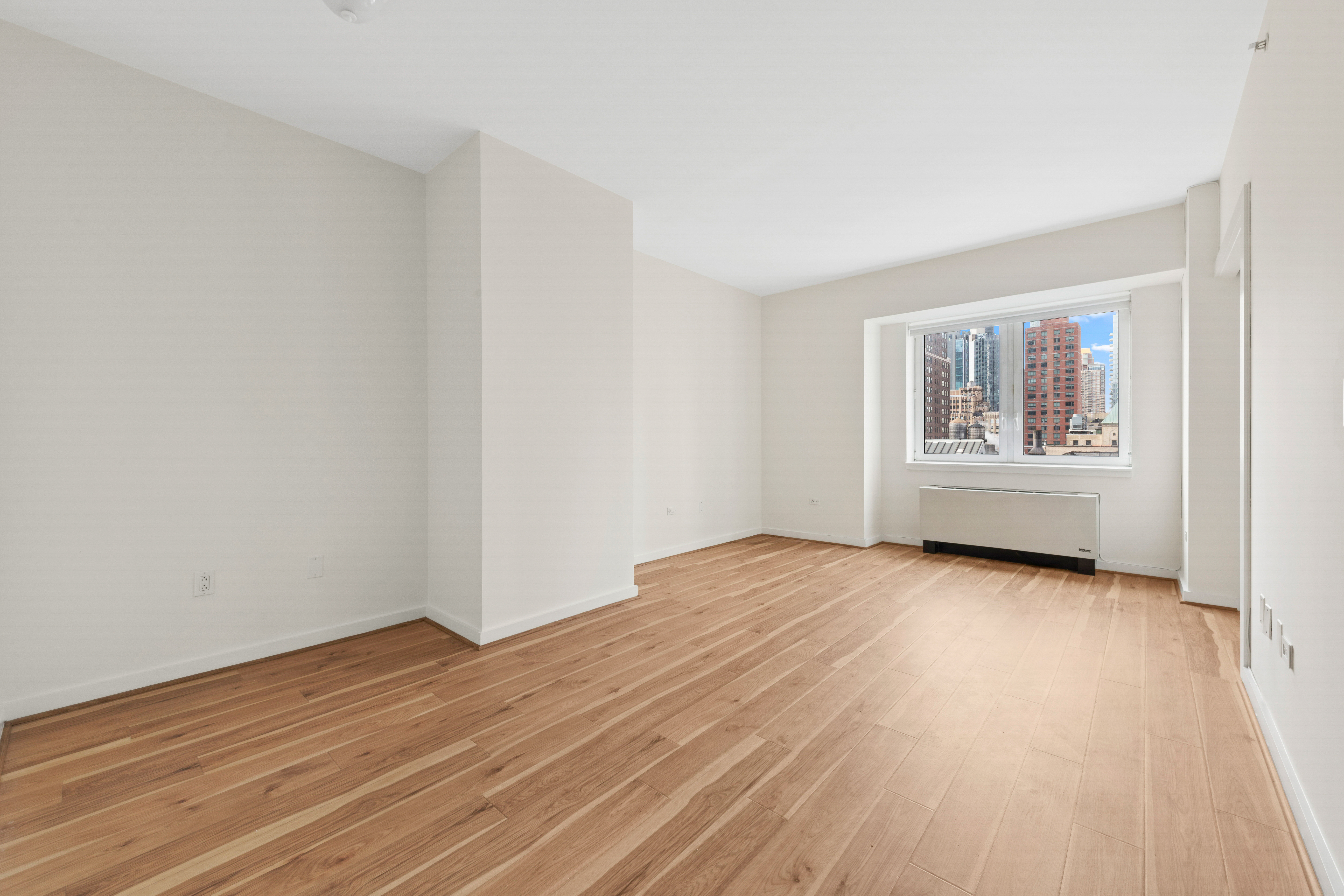 425 5th Avenue, Unit 23D Manhattan, NY 10016 - Photo 2 of 20 a view of an empty room with a window and wooden floor