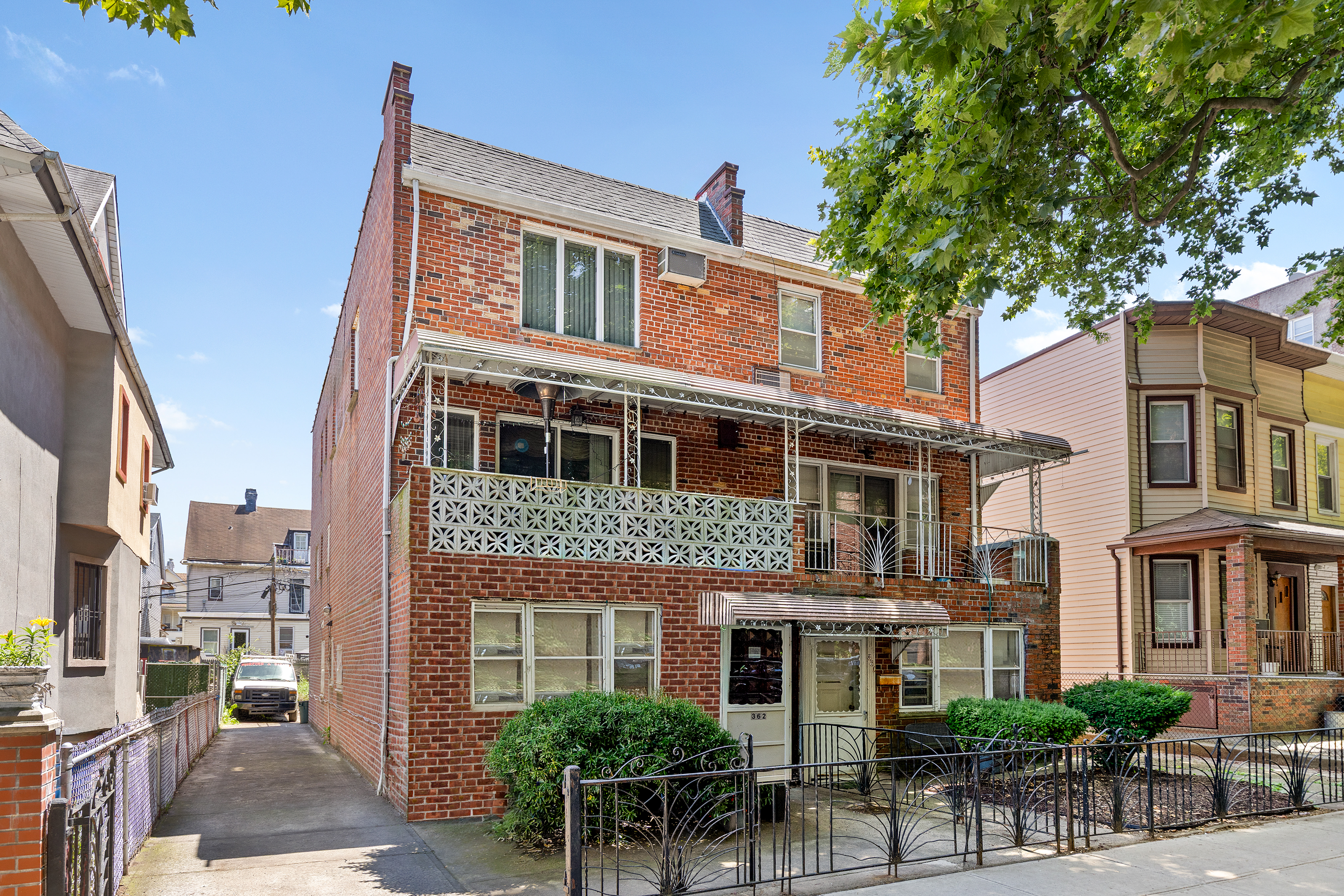 a front view of a building with outdoor seating and a tree
