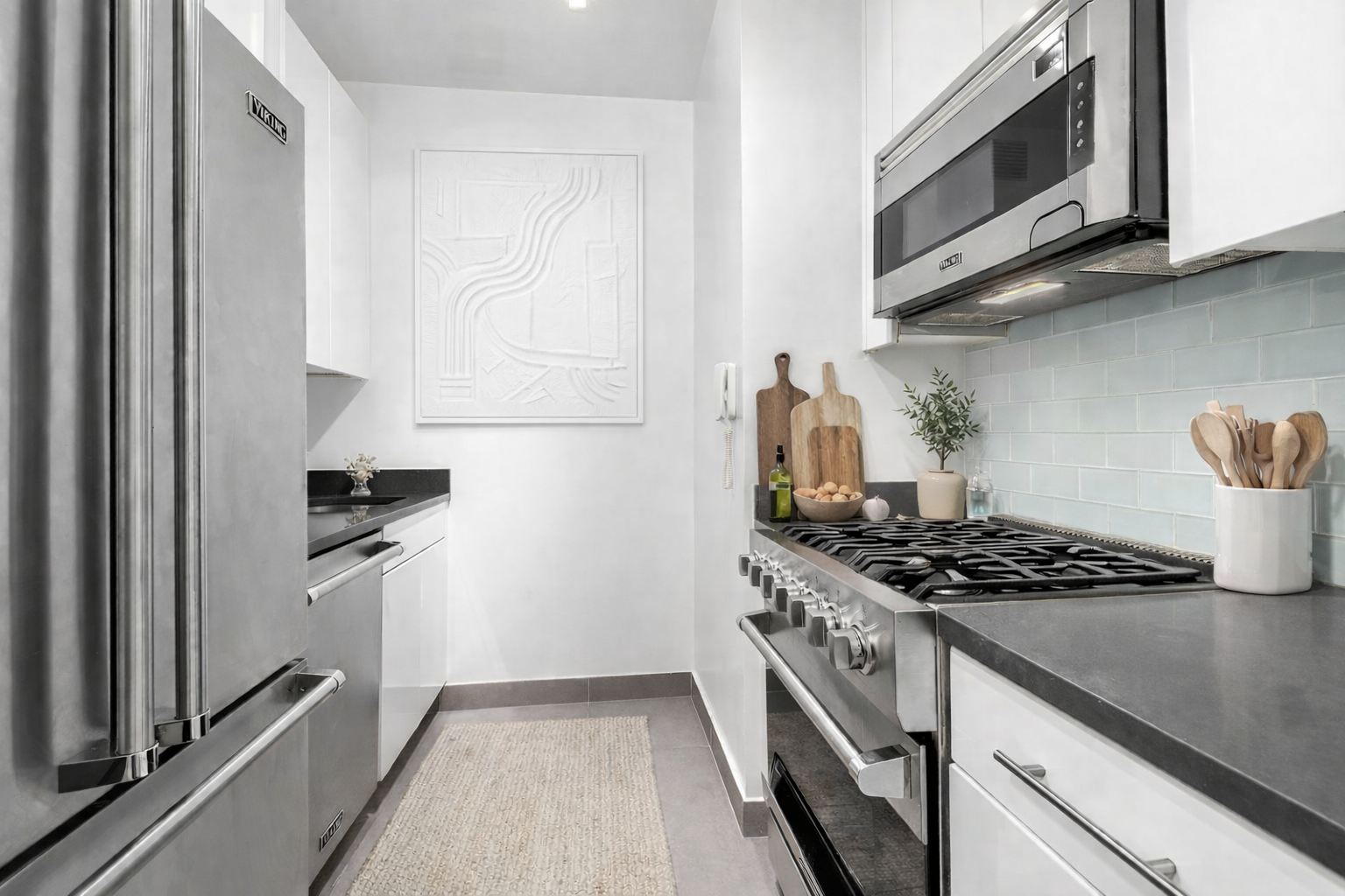 99 John Street, Unit 819 Manhattan, NY 10038 - Photo 4 of 20 a kitchen with stainless steel appliances granite countertop white cabinets and a stove