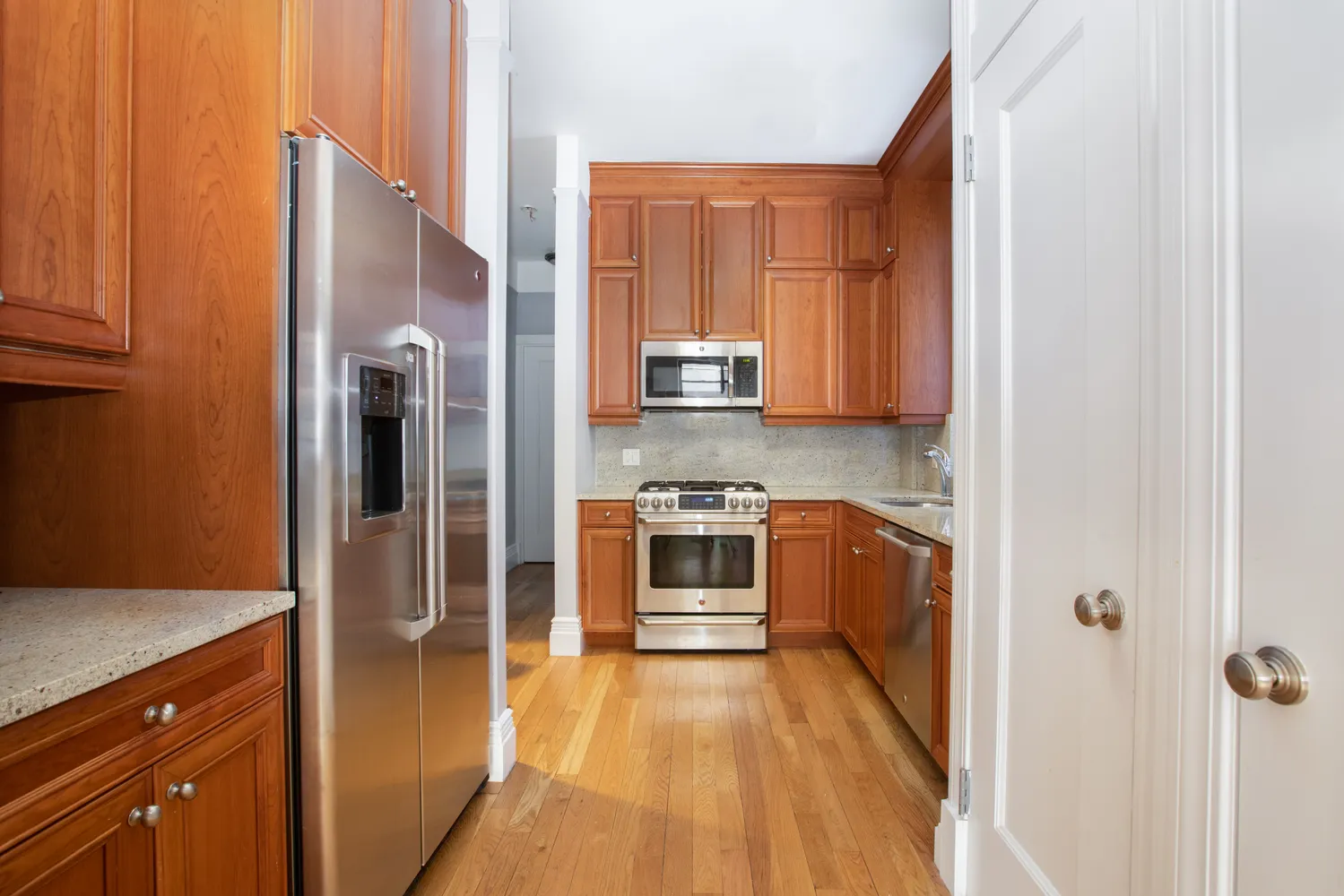 a kitchen with stainless steel appliances granite countertop a refrigerator and a stove top oven