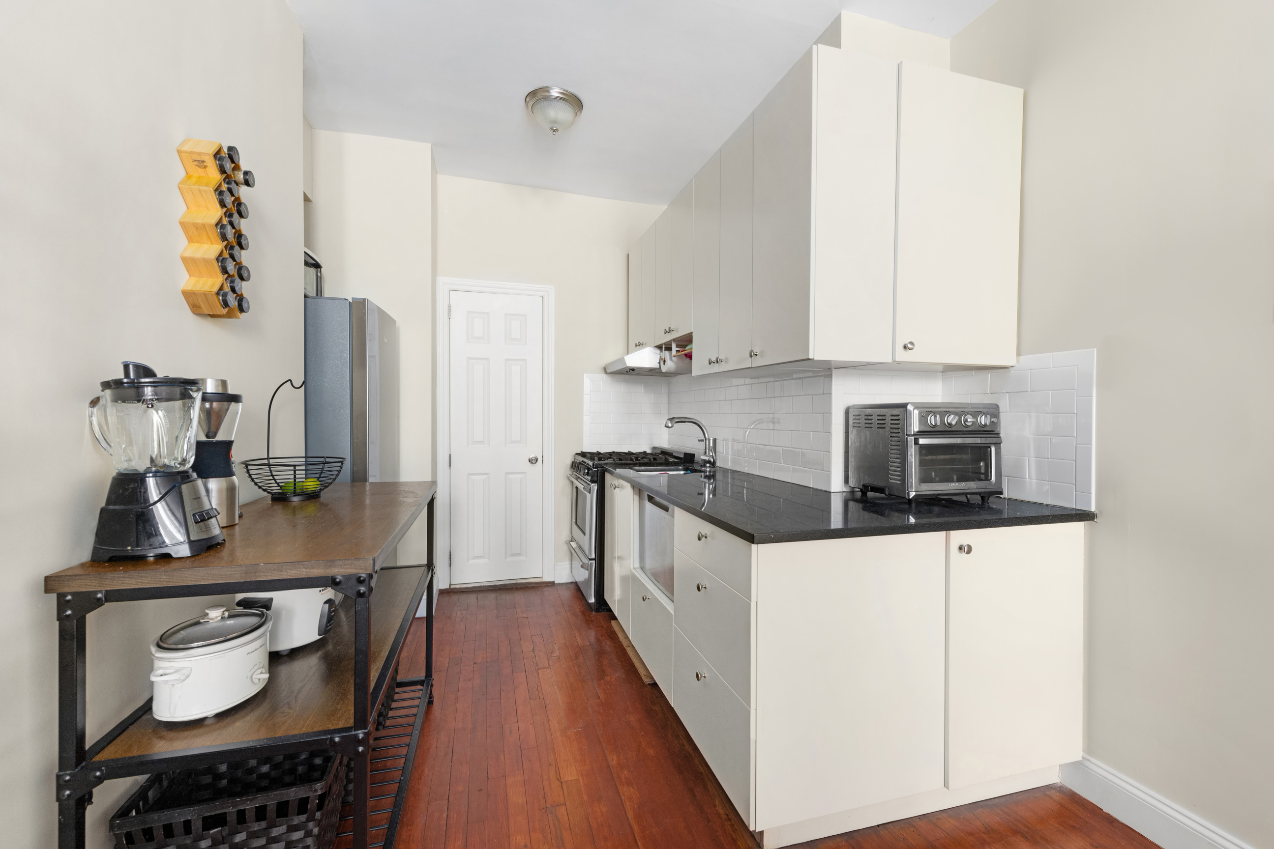 143 Sullivan Street, Unit G2 Manhattan, NY 10012 - Photo 3 of 5 a kitchen with stainless steel appliances a stove a sink and a refrigerator