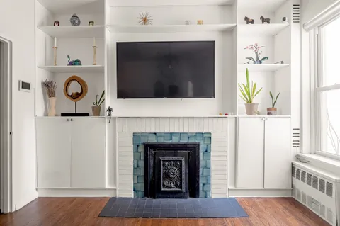 a living room with a fireplace and a wooden floor