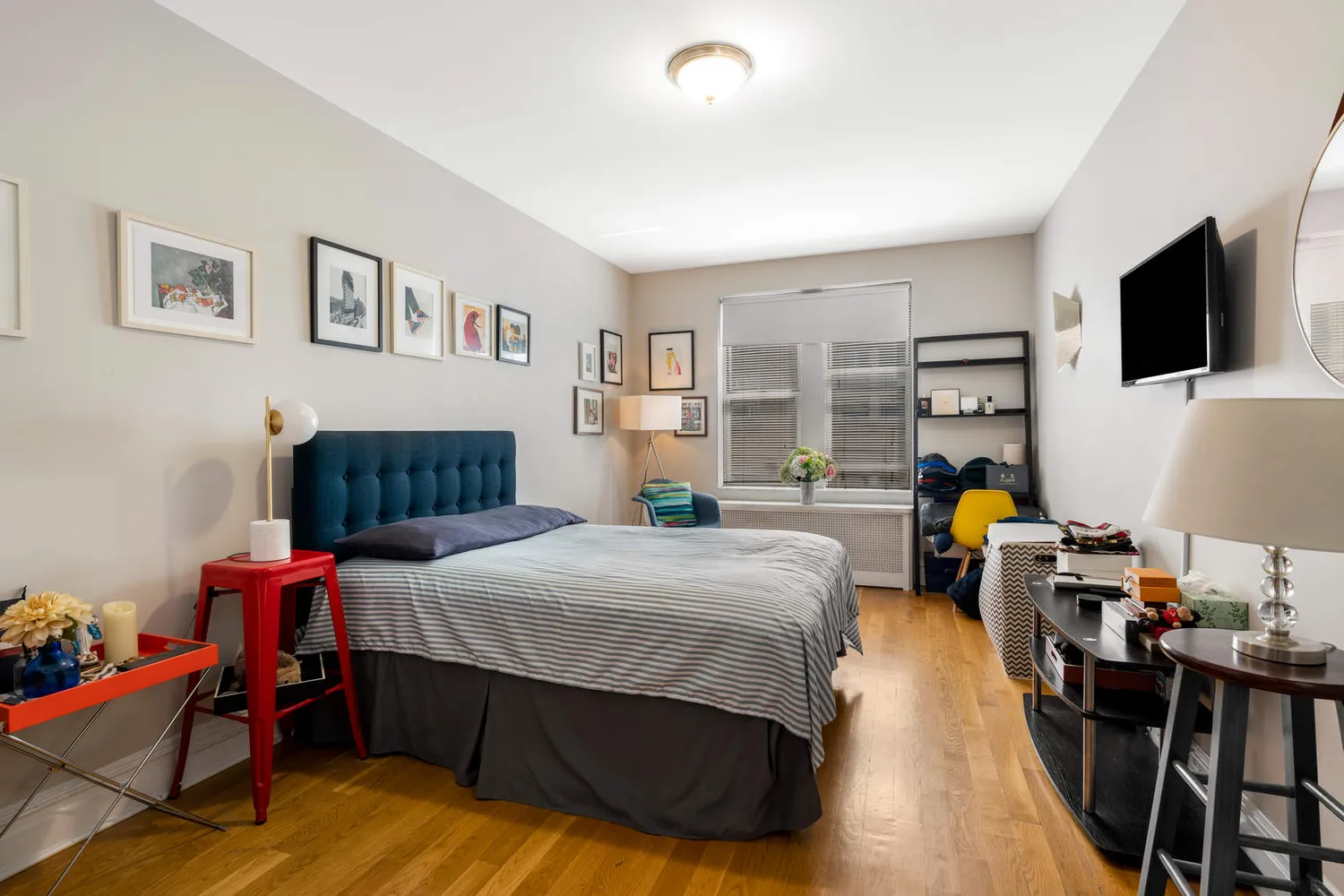 a bedroom with a bed a couch and a flat screen tv