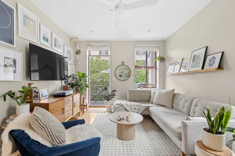 a living room with furniture a flat screen tv and a window