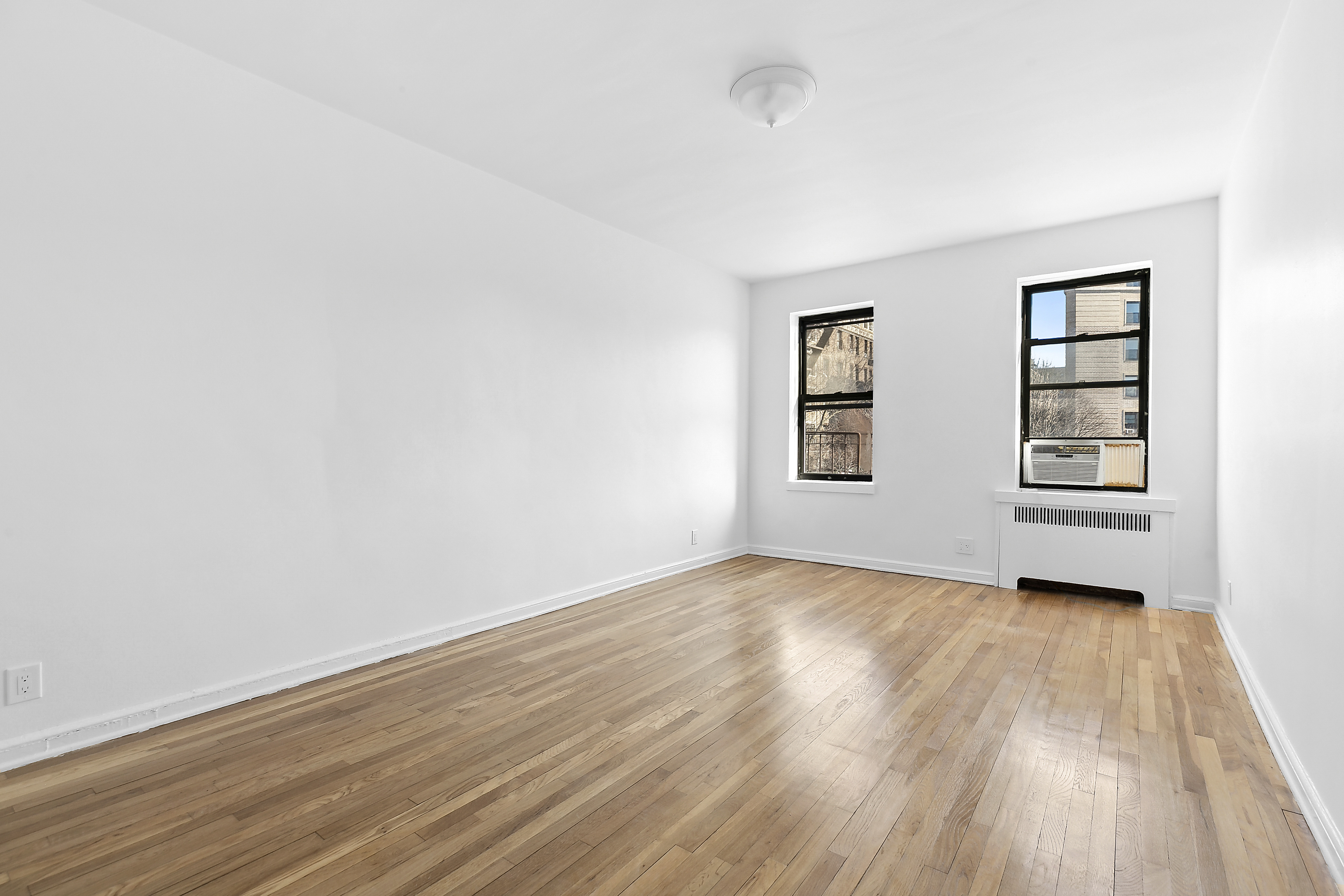 159-34 Riverside Drive West, Unit 5F90 Manhattan, NY 10032 - Photo 11 of 23 an empty room with wooden floor and windows