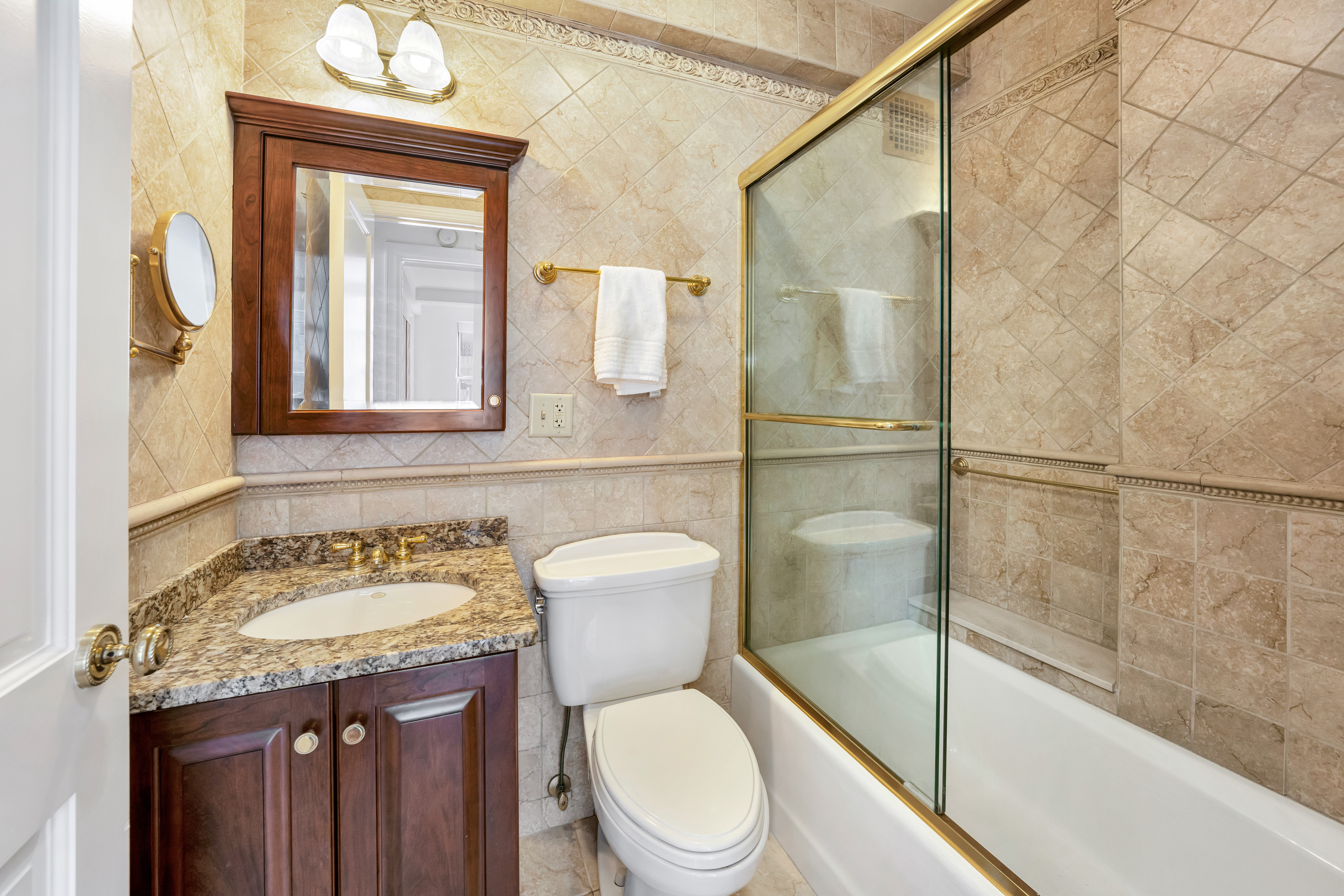 47 East 88th Street, Unit 15A Manhattan, NY 10128 - Photo 14 of 21 a bathroom with a granite countertop toilet sink and mirror