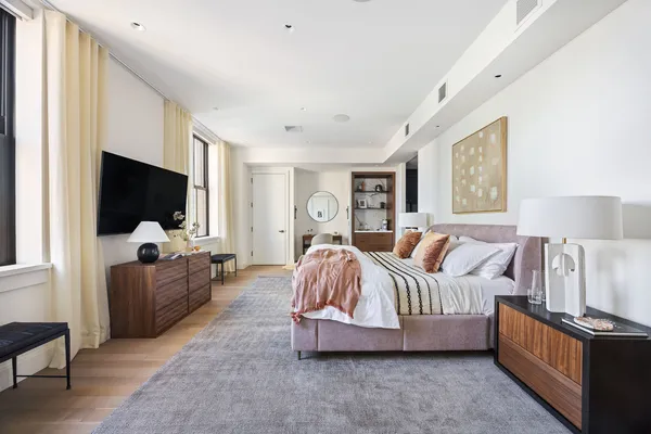 a bedroom with furniture and a flat screen tv