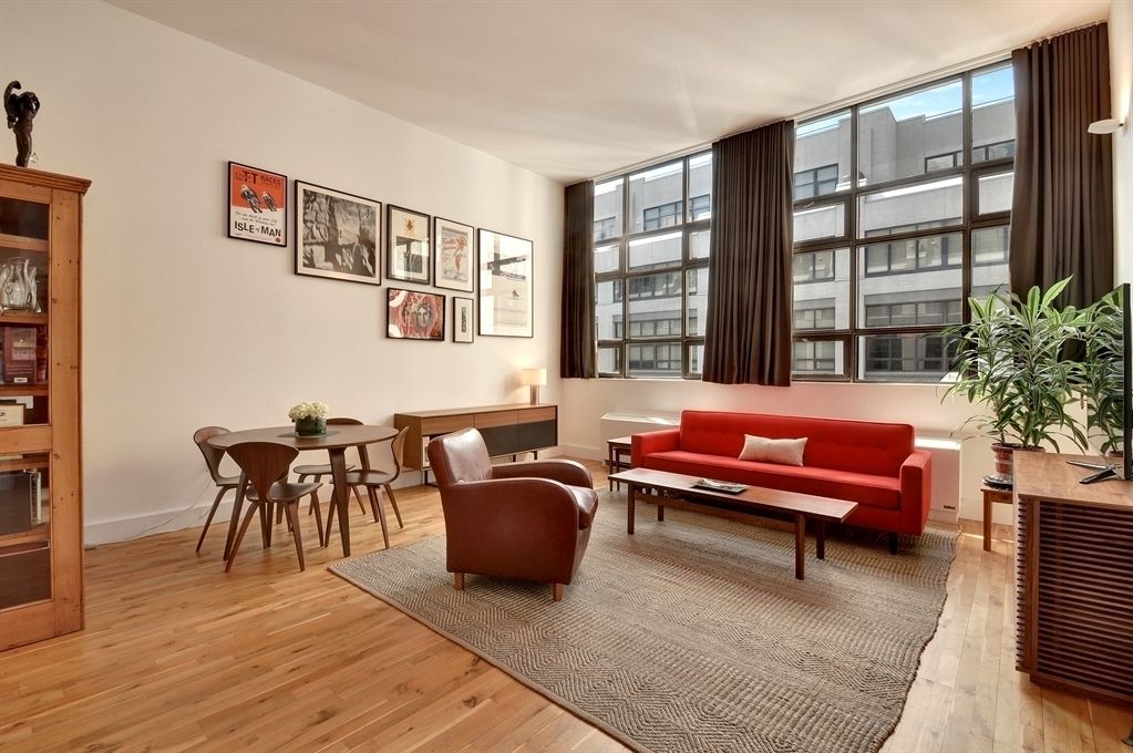 a living room with furniture a piano and a bookshelf