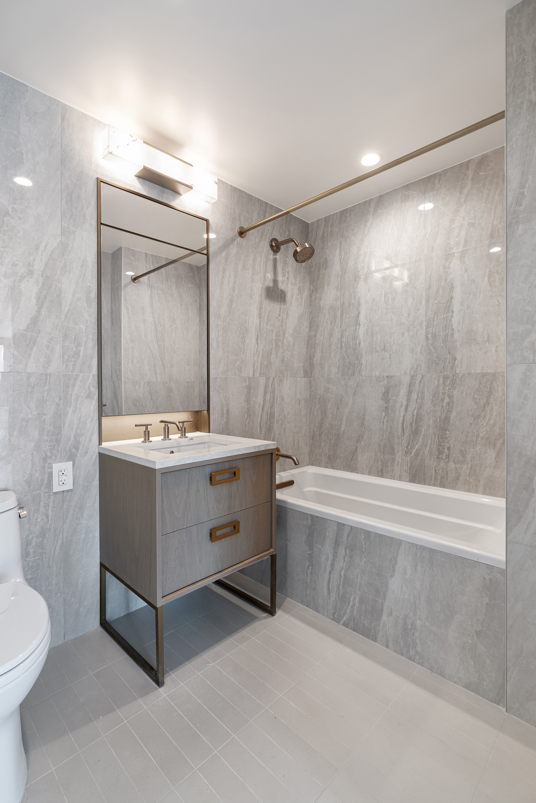 3 Court Square, Unit 2911 Queens, NY 11101 - Photo 8 of 22 a bathroom with a double vanity sink toilet mirror and bathtub