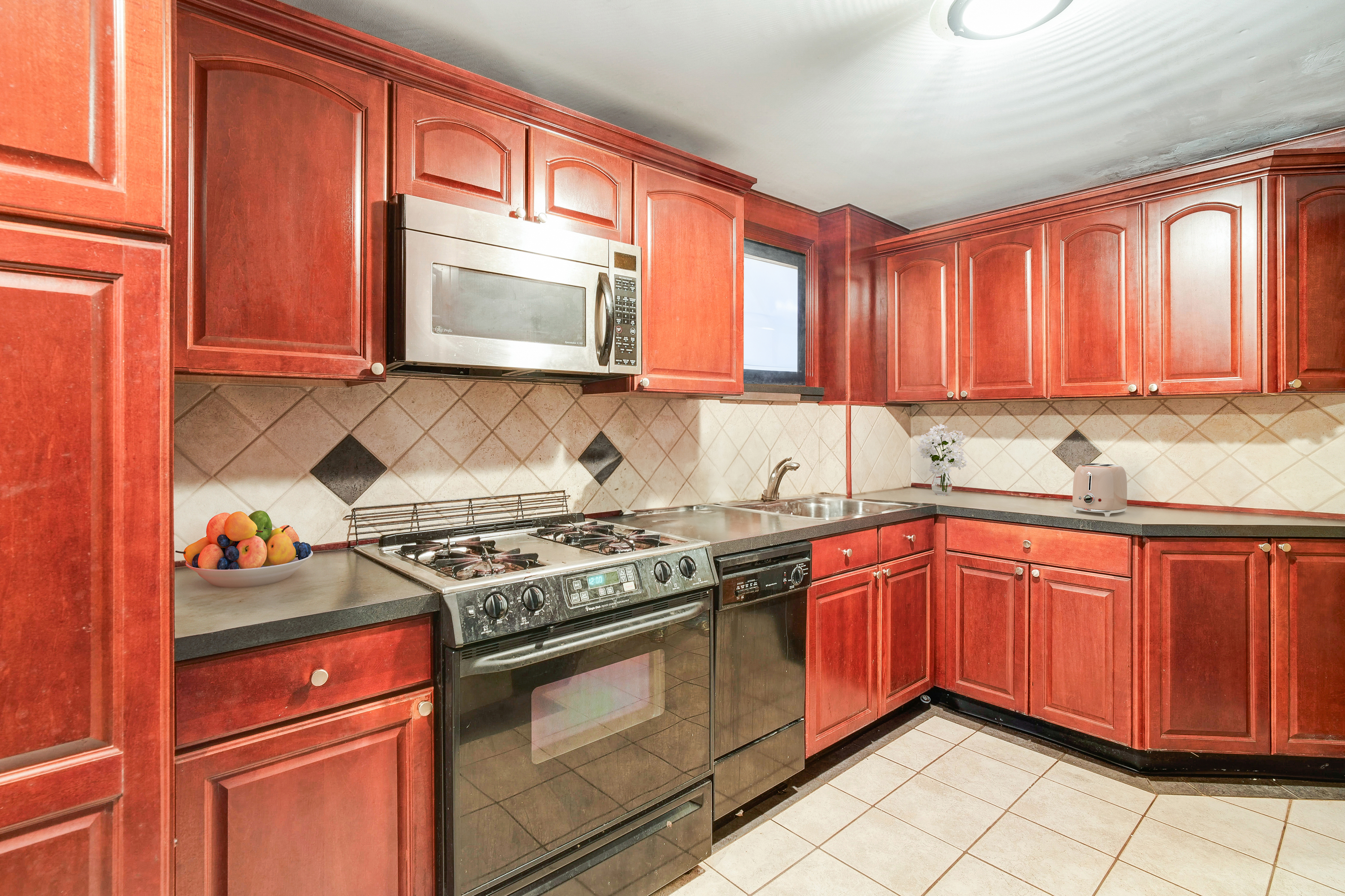 233 Battery Avenue Brooklyn, NY 11209 - Photo 16 of 26 a kitchen with stainless steel appliances granite countertop a stove sink and cabinets