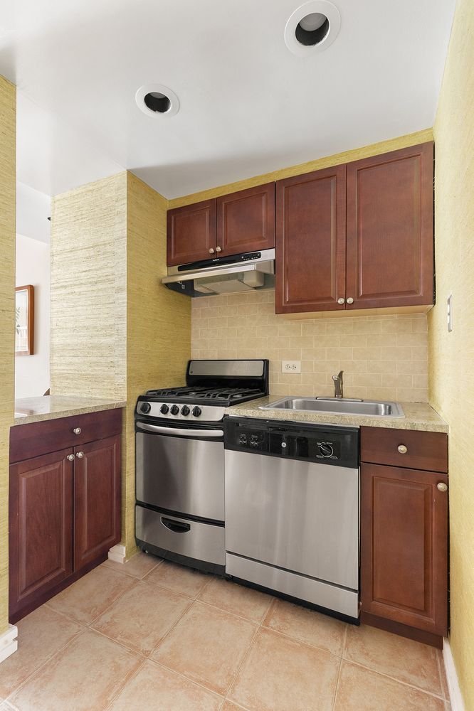 60 East 79th Street, Unit 3B Manhattan, NY 10075 - Photo 4 of 8 a kitchen with stainless steel appliances granite countertop a stove and a sink
