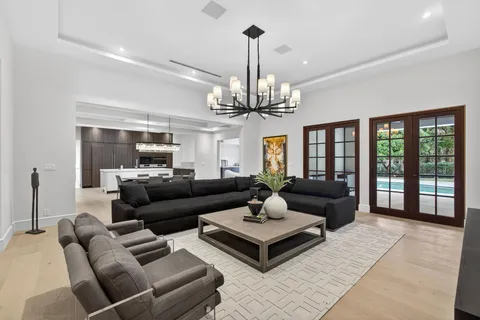 a living room with furniture a chandelier and a dining table