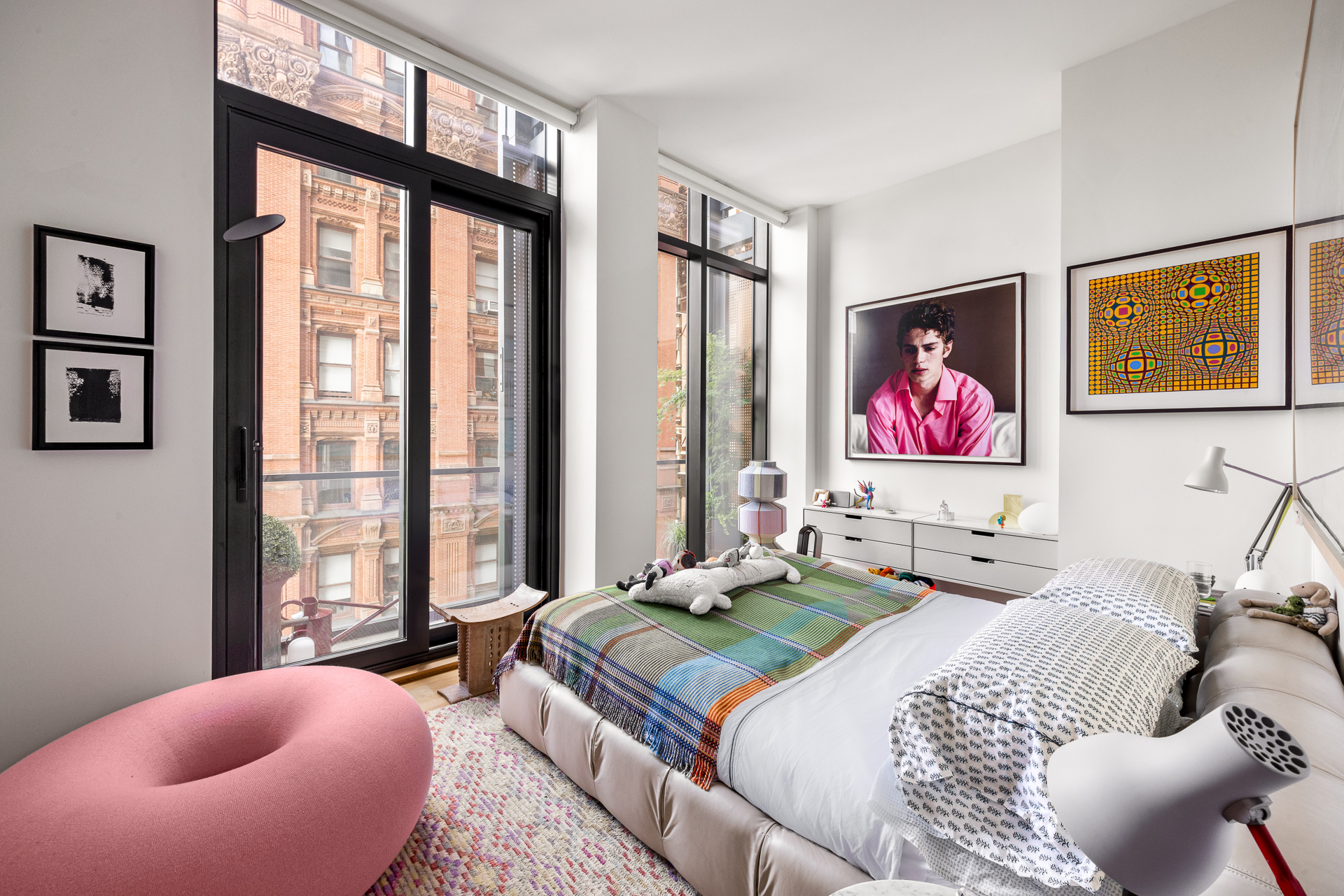 33 Park Row, Unit 6B Manhattan, NY 10038 - Photo 9 of 20 a bedroom with a bed and glass windows