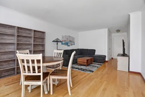 a living room with a bed and a wooden floor