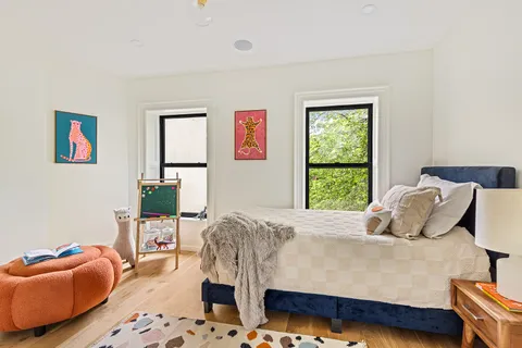 a bedroom with a bed and dresser with rug