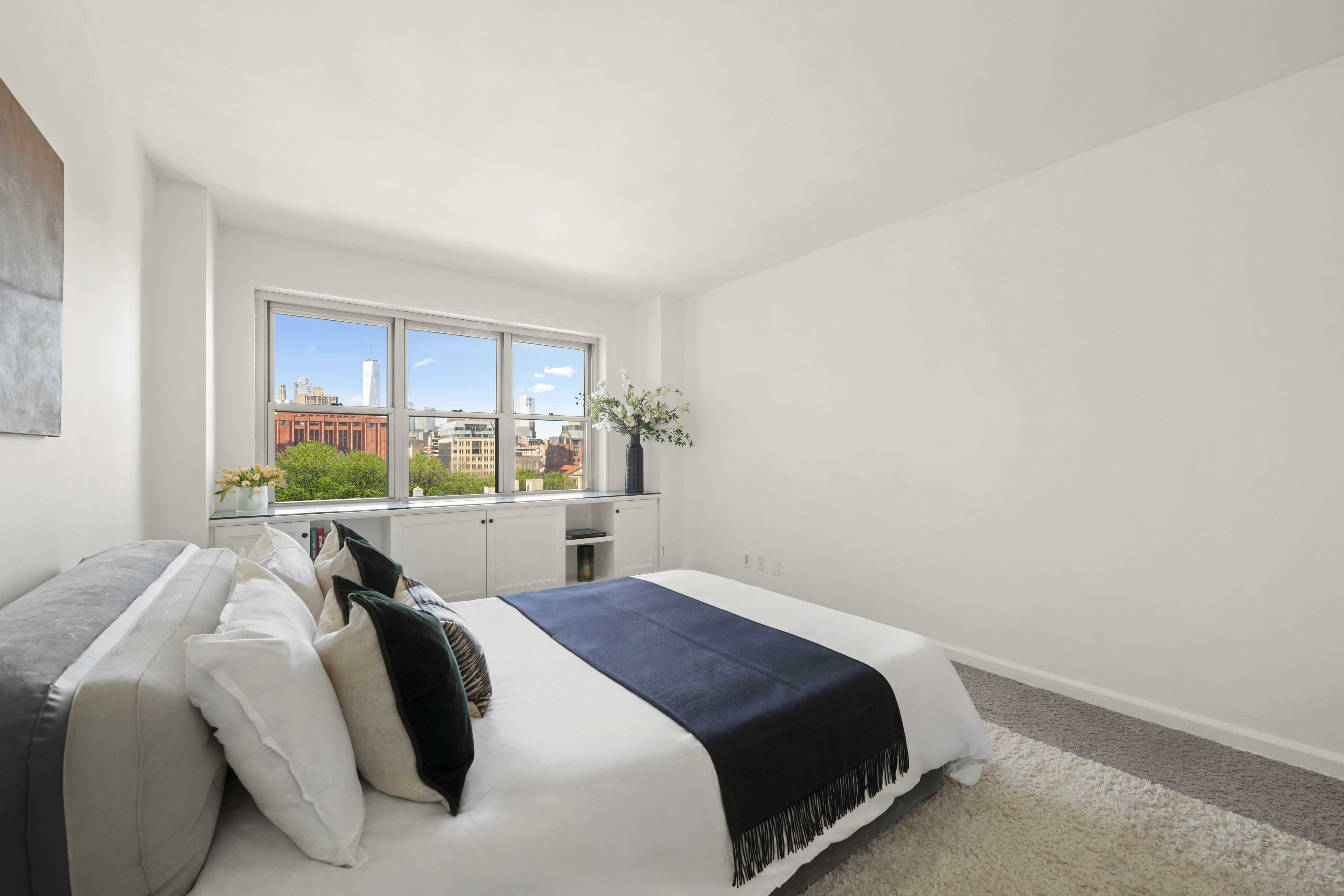 20 East 9th Street, Unit 11M Manhattan, NY 10003 - Photo 11 of 28 a bed sitting in a bedroom next to a window with a balcony