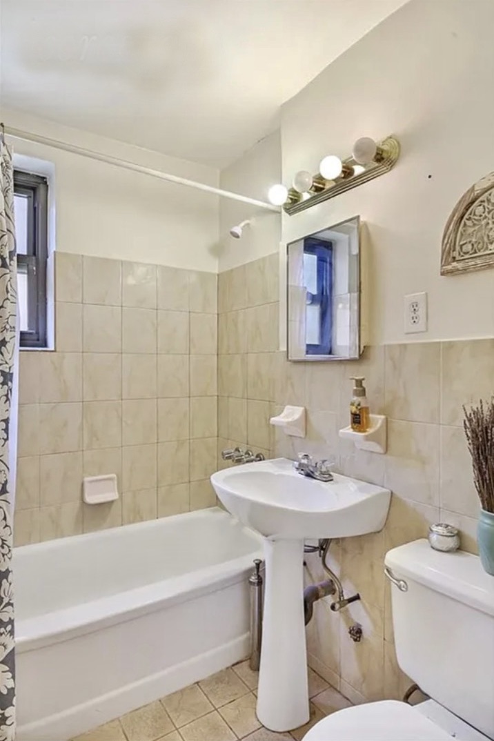 4523 Broadway, Unit 5D Manhattan, NY 10040 - Photo 4 of 10 a bathroom with a sink a toilet and bathtub