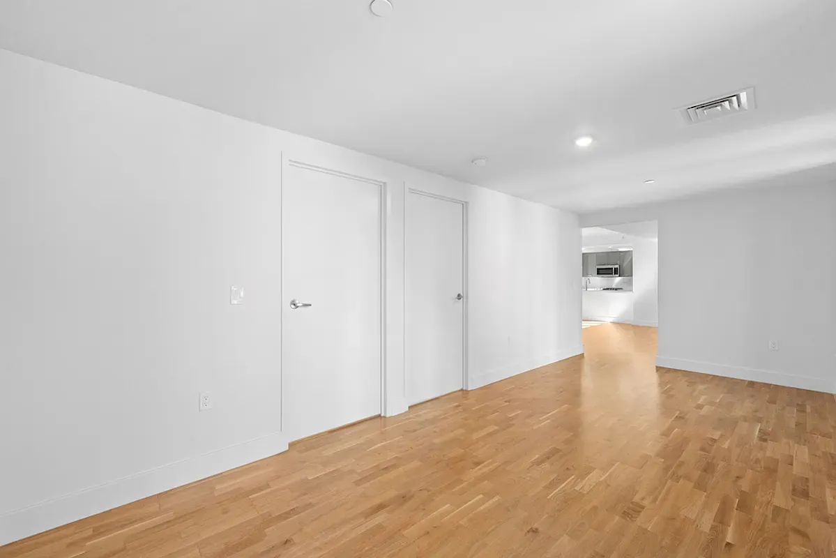 a view of an empty room with wooden floor