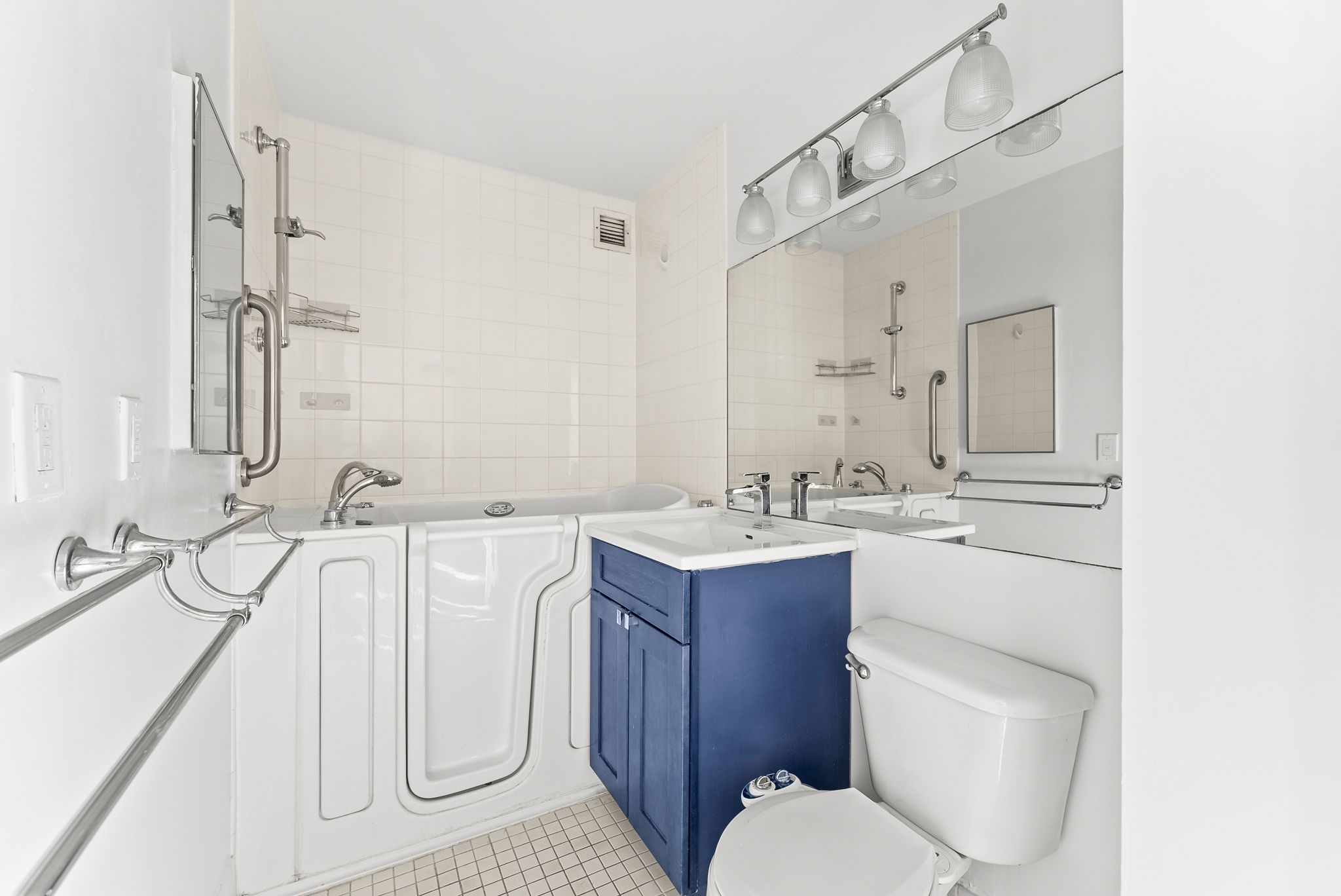 1919 Madison Avenue, Unit 214 Manhattan, NY 10035 - Photo 8 of 19 a bathroom with a double vanity sink toilet and mirror