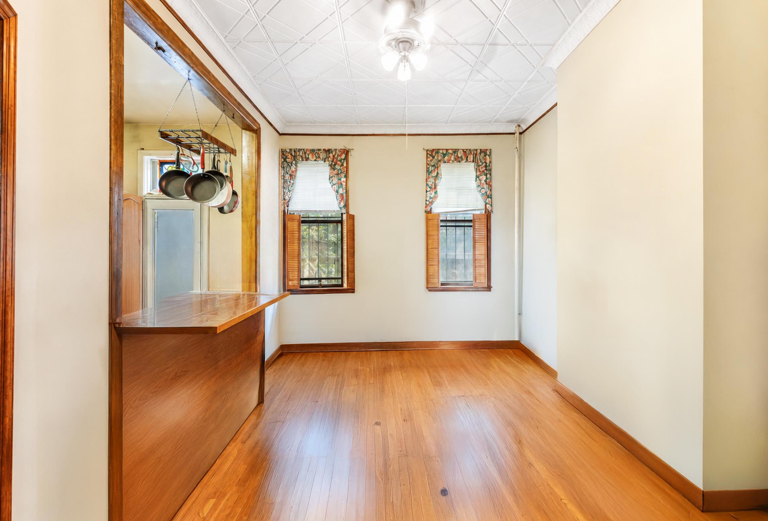 949 4th Avenue Brooklyn, NY 11232 - Photo 3 of 21 a view of an empty room with wooden floor and a window