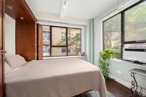 a large bed sitting in a bedroom next to a window