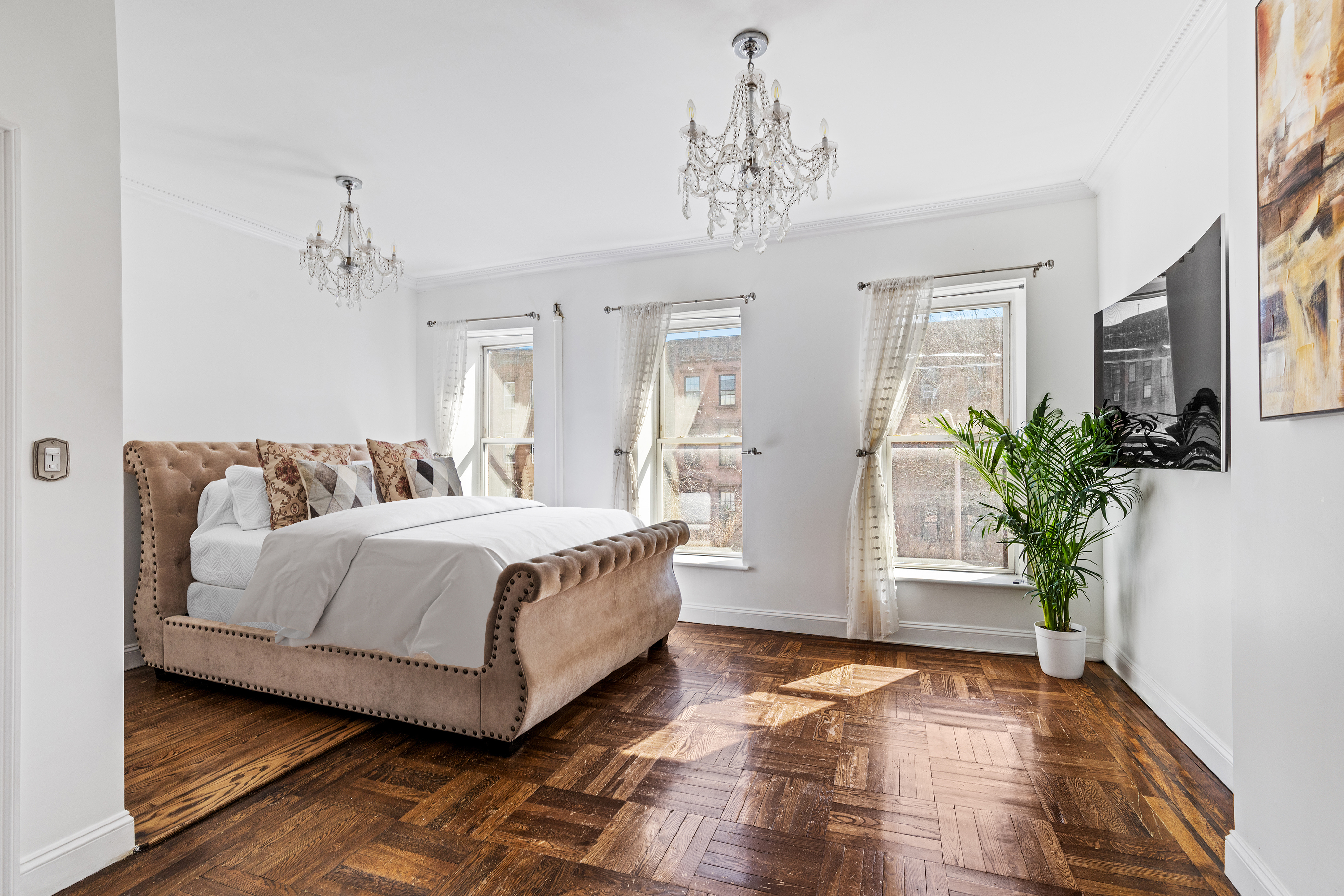 231 Vernon Avenue Brooklyn, NY 11206 - Photo 6 of 13 a spacious bedroom with a bed and a chandelier