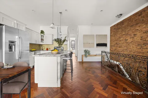 a kitchen with stainless steel appliances a refrigerator a sink dishwasher a oven with white cabinets and wooden floor