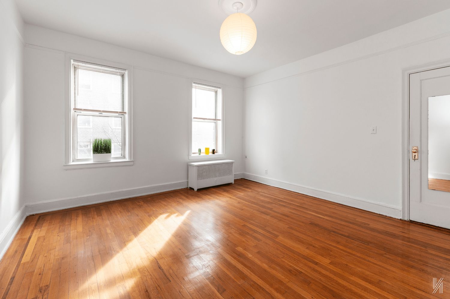 59-11 Queens Boulevard, Unit 3J Queens, NY 11377 - Photo 11 of 18 an empty room with wooden floor and windows