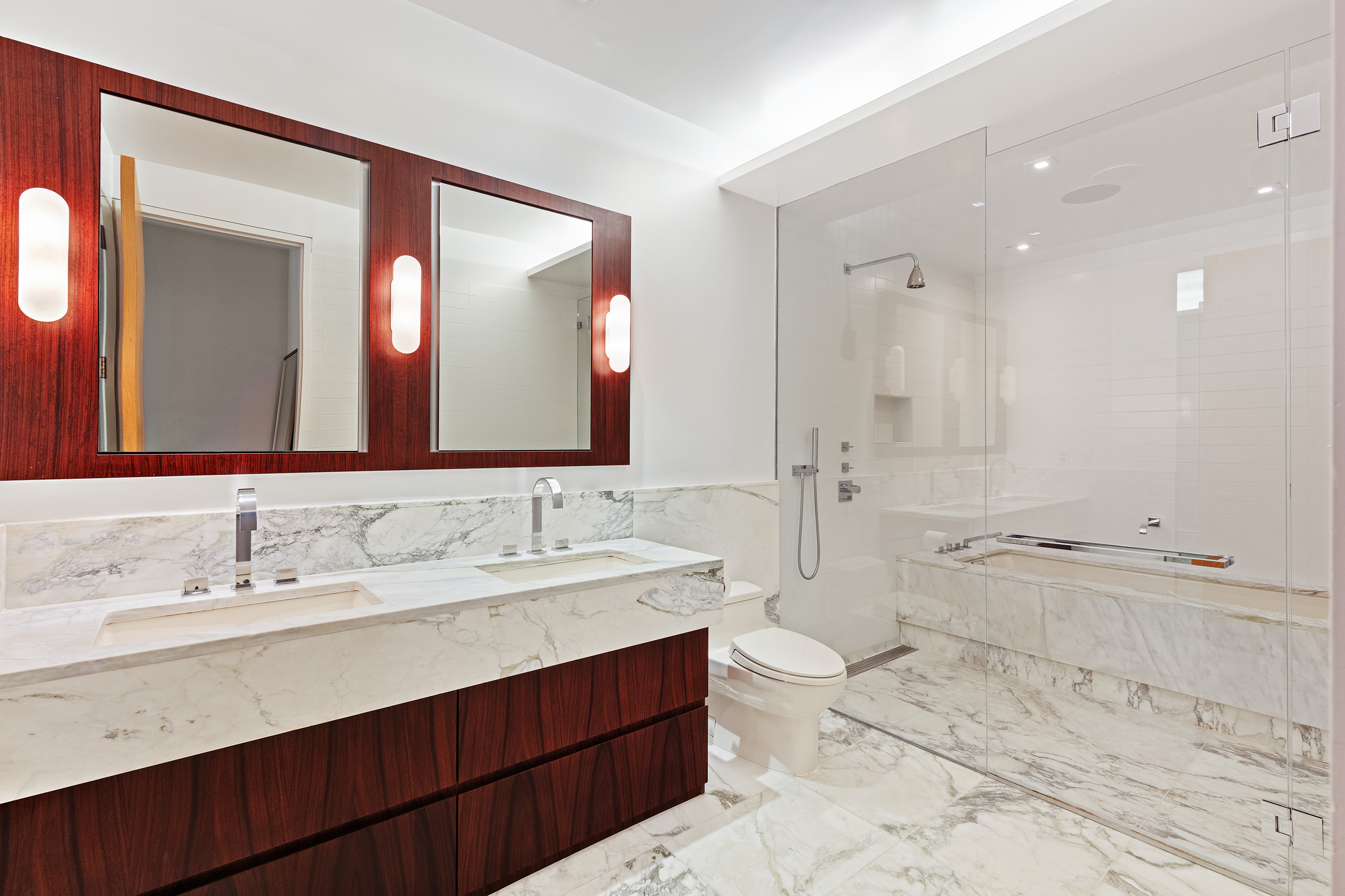 122 Greenwich Avenue, Unit 6 Manhattan, NY 10011 - Photo 6 of 13 a bathroom with a double vanity sink large mirror and a bathtub