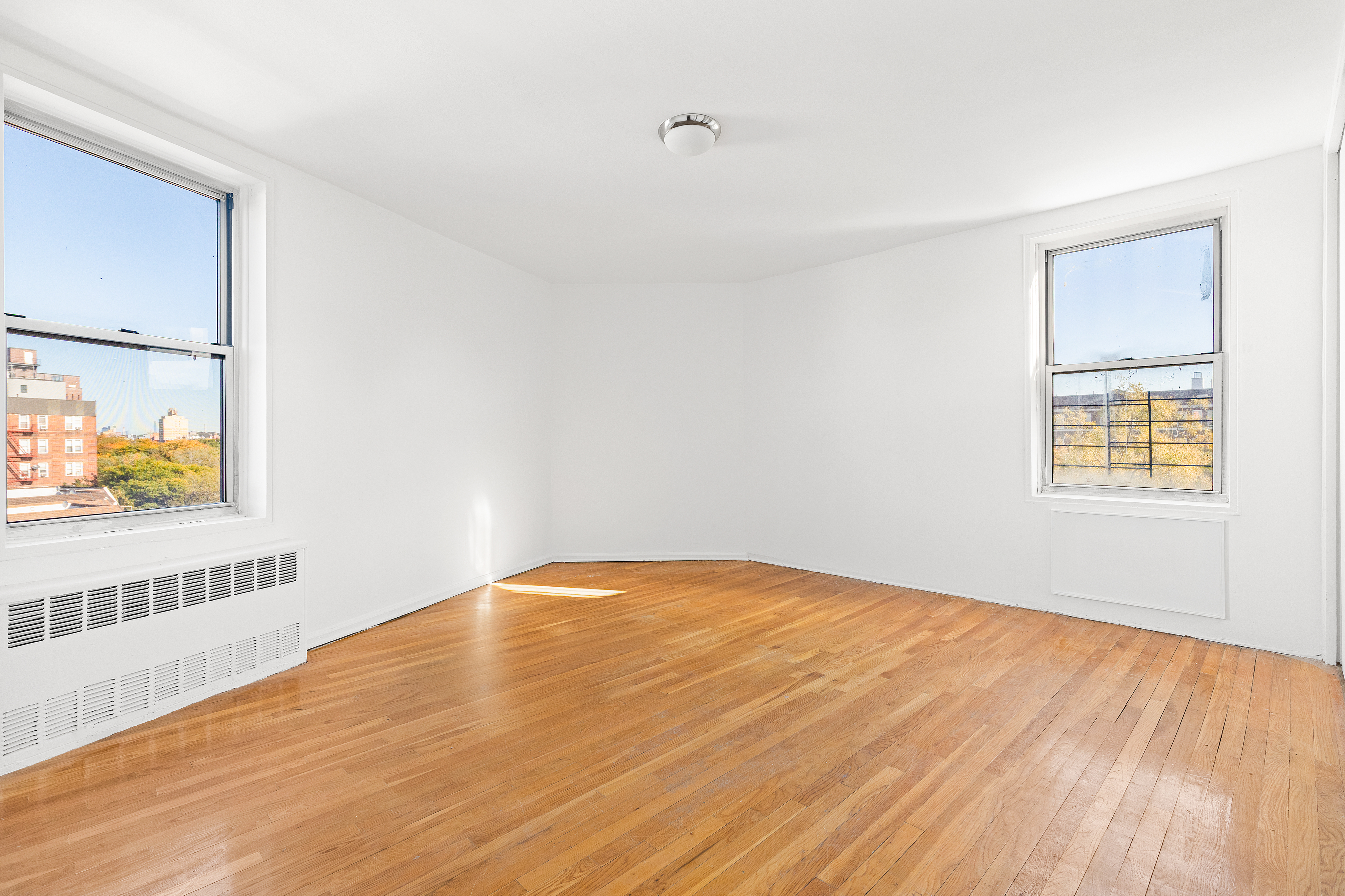 770 Ocean Parkway, Unit 6F Brooklyn, NY 11230 - Photo 4 of 17 a view of an empty room with wooden floor and a window
