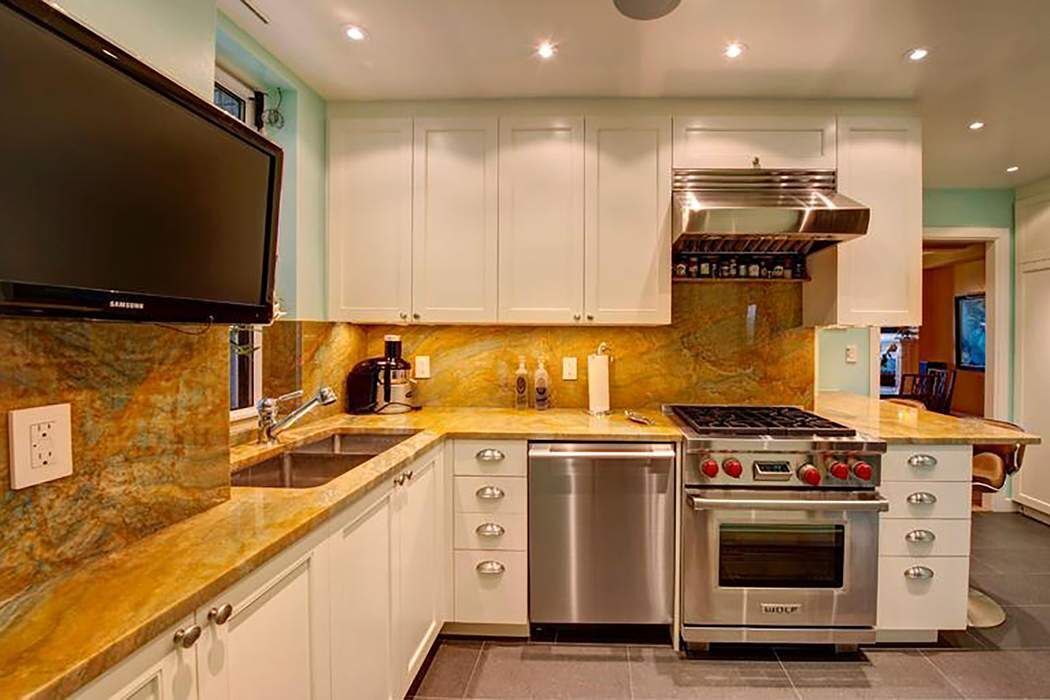128 Central Park South, Unit 9B Manhattan, NY 10019 - Photo 5 of 11 a kitchen with stainless steel appliances a stove a sink and a microwave
