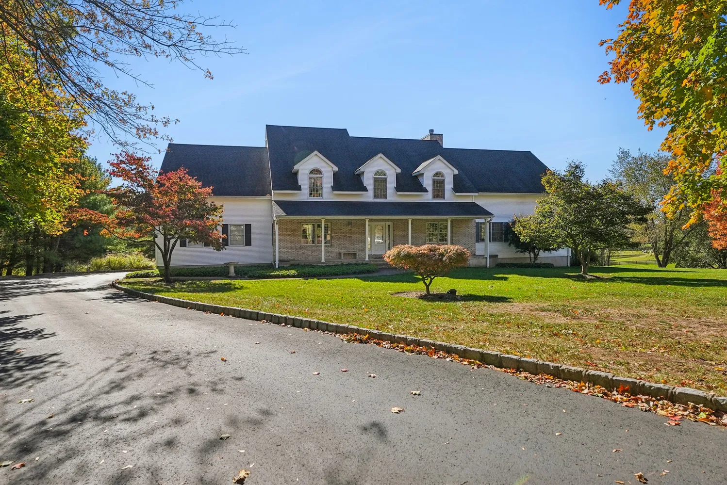 a view of a house with a big yard and large trees