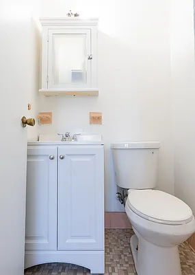 148 Cozine Avenue, Unit 1C Brooklyn, NY 11207 - Photo 7 of 8 a bathroom with a toilet a sink and cabinet