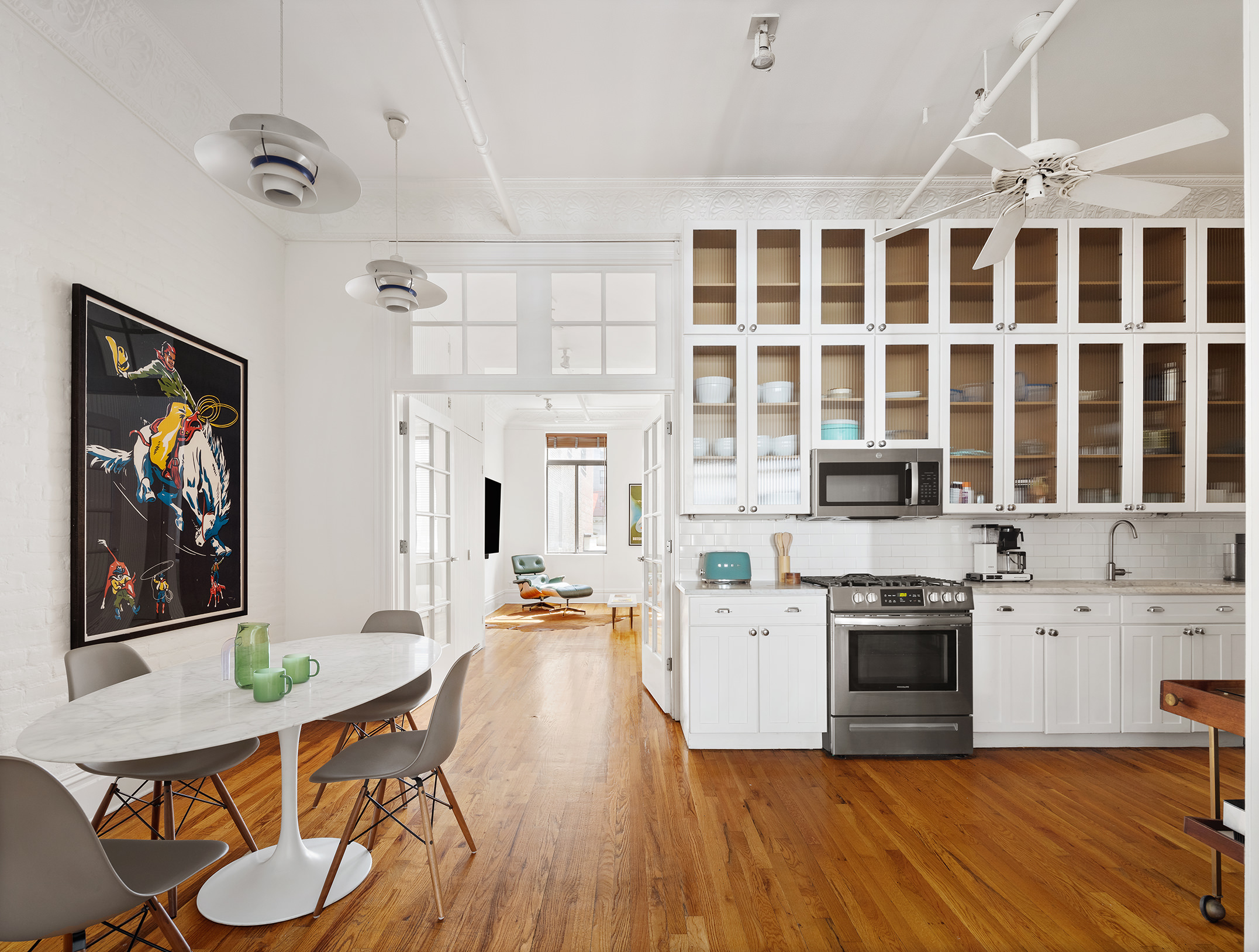99 Reade Street, Unit 4E Manhattan, NY 10013 - Photo 4 of 11 a view of a kitchen with a dining table wooden floor and a fireplace
