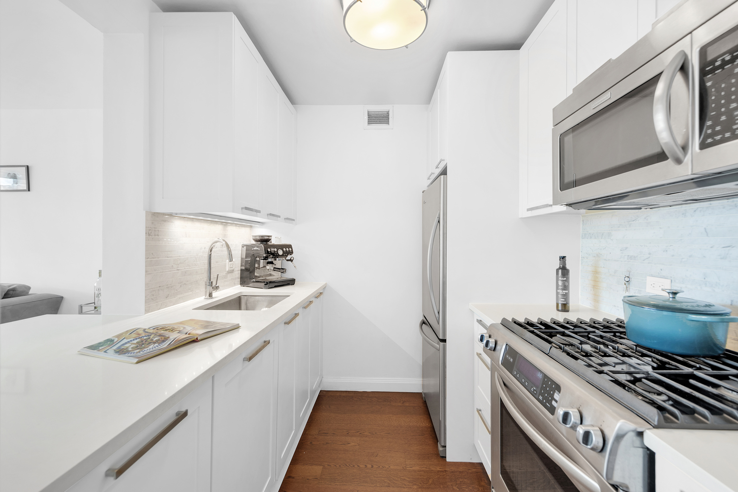 200 East 94th Street, Unit 1412 Manhattan, NY 10128 - Photo 4 of 15 a kitchen with a sink stove and microwave