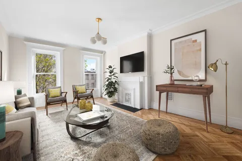 a work room with furniture a flat screen tv and a potted plant